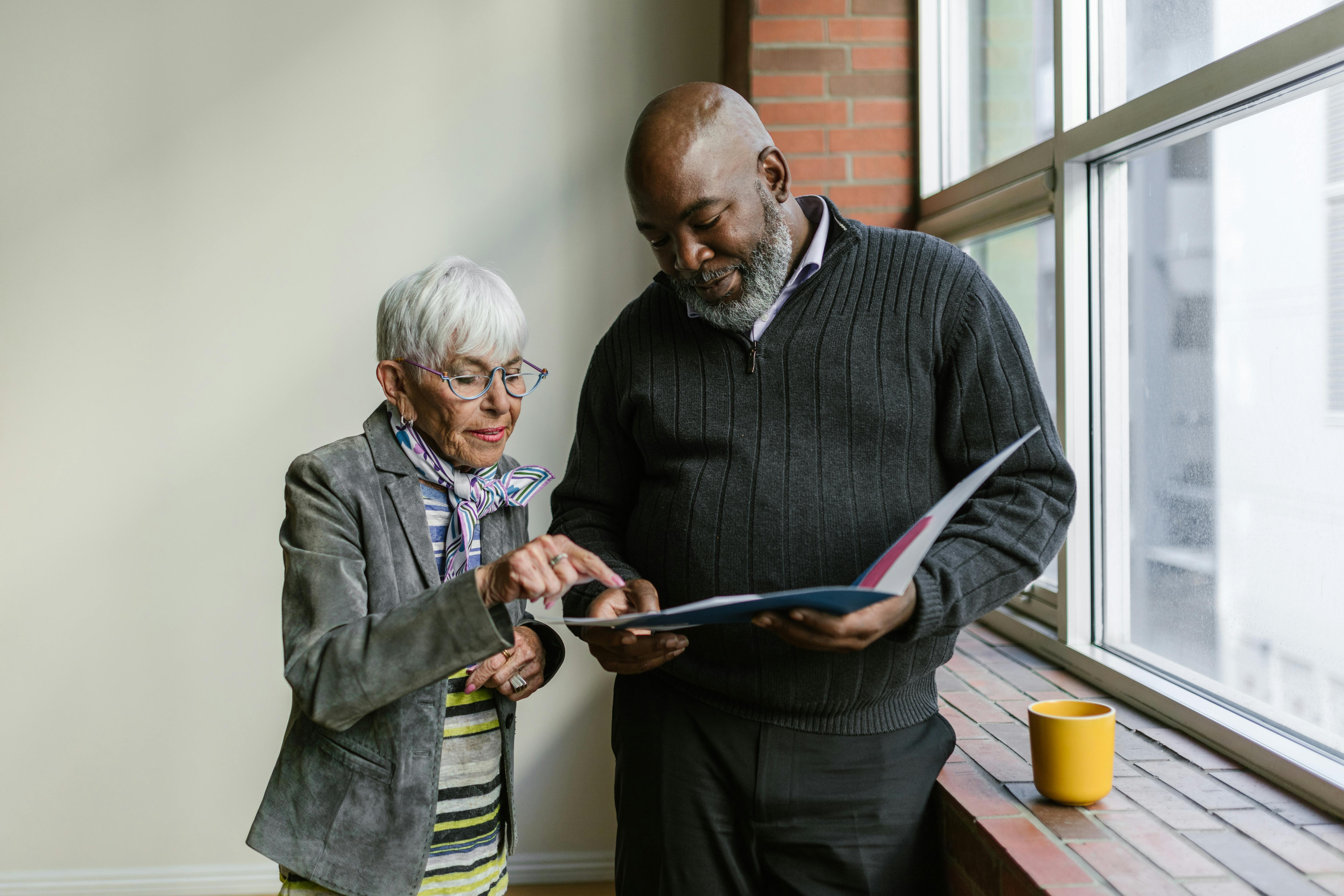 Tall black man being helpful to an elderly woman