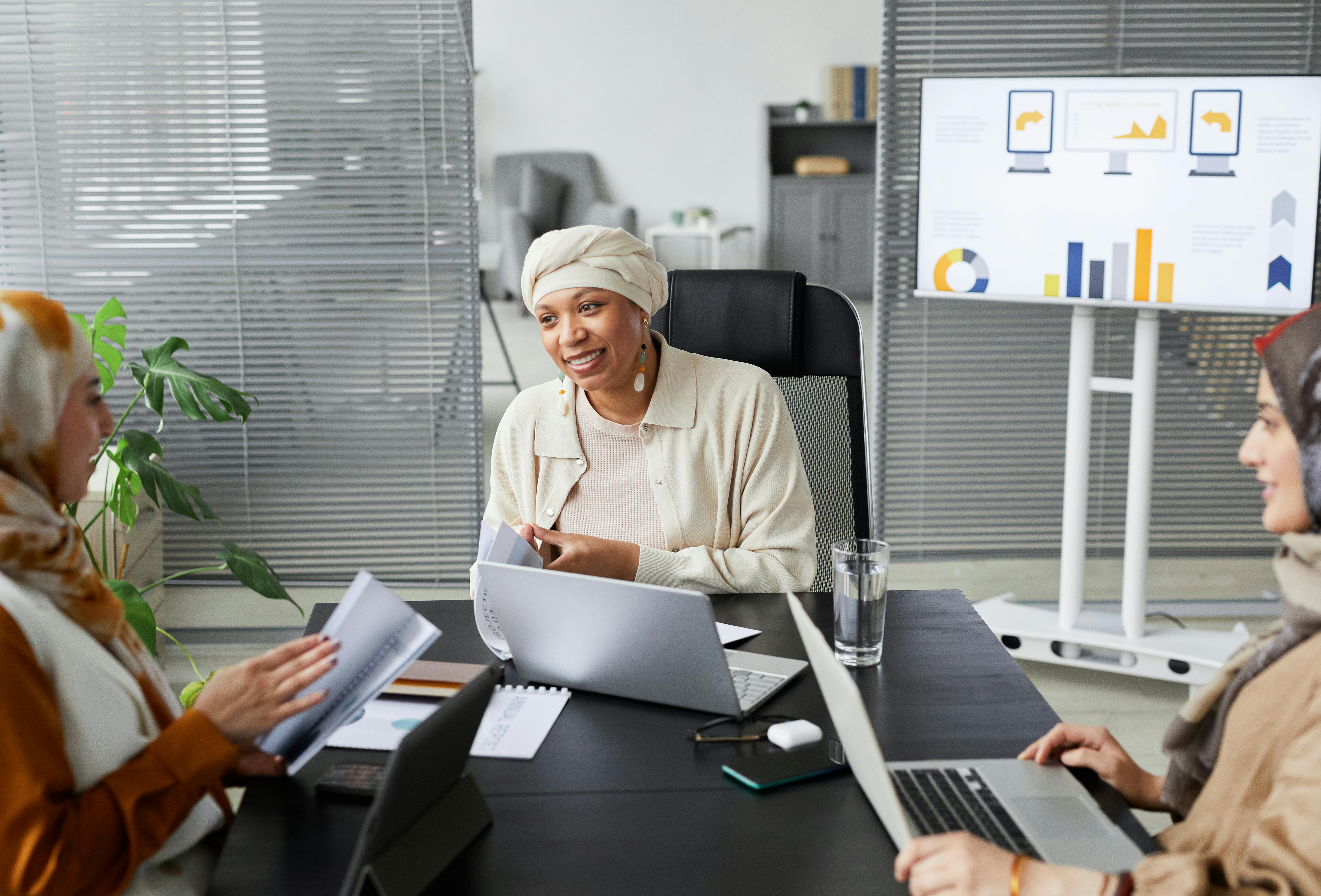 3 women sitting at a table discussing business